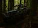 1990 Ford Bronco - A custom-built off-road buggy, identified by the number 24, navigates a challenging wooded terrain.