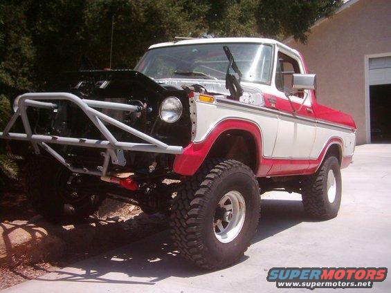 White and red Ford Bronco with a custom front bumper and hood open