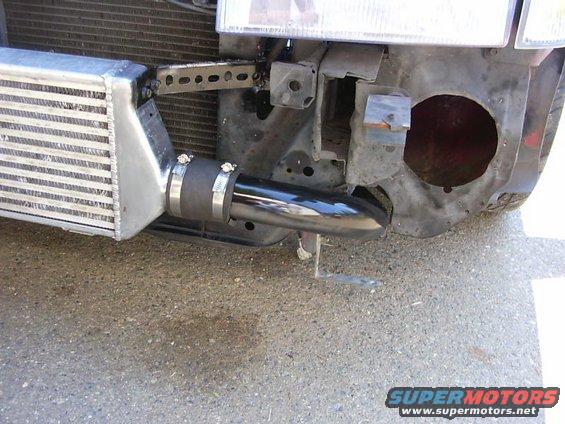 Aftermarket intercooler and black piping attached to a vehicle's front end