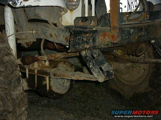 Close-up of a vehicle's rusty frame, leaf springs, and rear axle