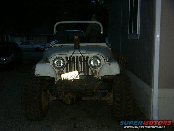 White Jeep CJ-5 with large tires and a winch, front view