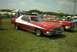 1967 Ford LTD - Two classic cars are parked on a grassy field under a partly cloudy sky at an outdoor event.