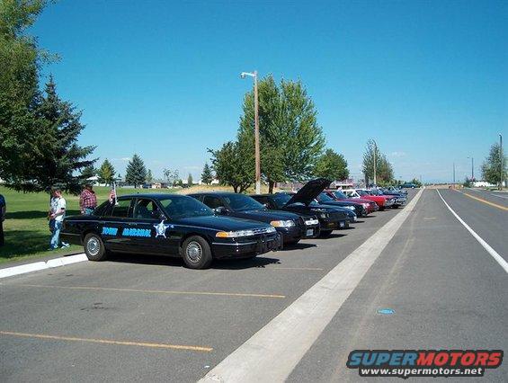 Black Ford Crown Victoria police car with "Town Marshal" text and badge on the side, parked in a lot