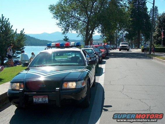 2001 Ford Crown Victoria police car, front view, parked in a line with other vehicles