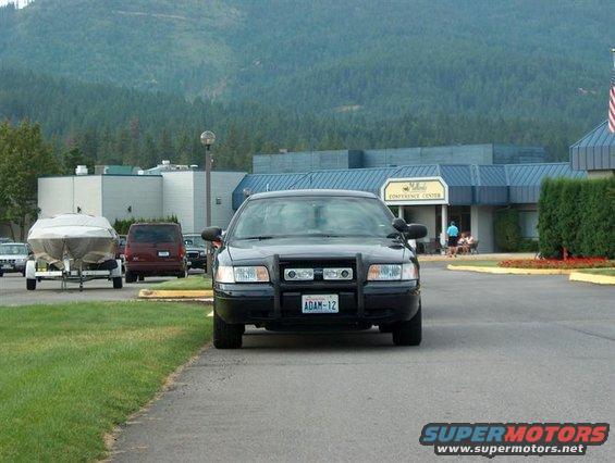 Black 2001 Ford Crown Victoria police car with a push bar, parked on asphalt