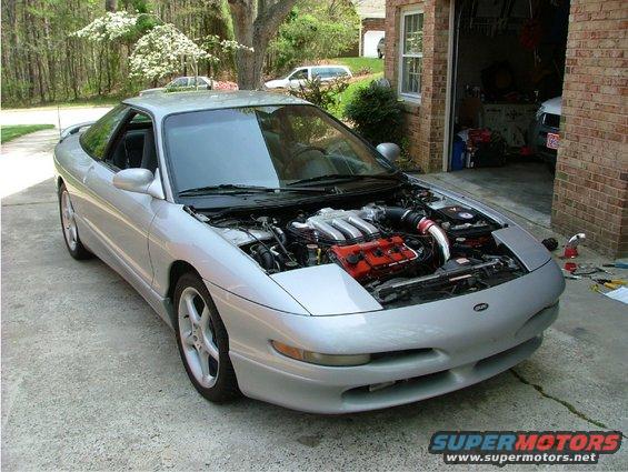 Silver 1995 Ford Probe with hood open, showing engine bay. Parked in driveway near garage