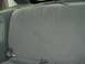 1989 Ford Escort - Interior view of a gray fabric rear seat with visible seatbelt buckles.