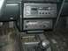 1989 Ford Escort - The interior of a car shows a manual transmission shifter, radio, and climate controls, with coins in the console.