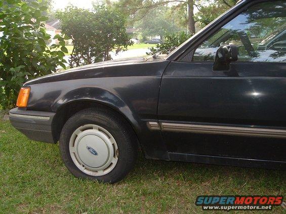 1989 Ford Escort side view, dark blue paint, parked on grass