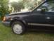 1989 Ford Escort - Side view of a 1989 Ford Escort, showing its dark blue paint and wheel cover.
