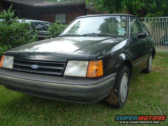 1989 Ford Escort coupe parked on grass, front 3/4 view