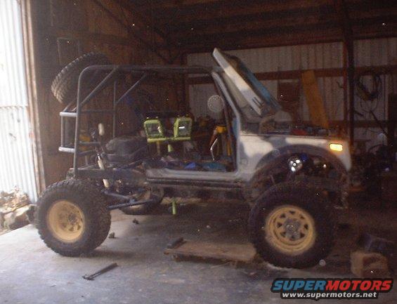 Off-road vehicle with roll cage, spare tire on back, and open doors