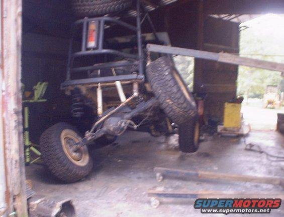 Off-road vehicle chassis with large tires, lifted by a crane
