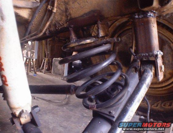 Close-up of rear suspension with coil spring and shock absorber