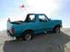 1994 Ford Bronco - A teal Ford Bronco is stuck in the sand with a red flag flying from its antenna.