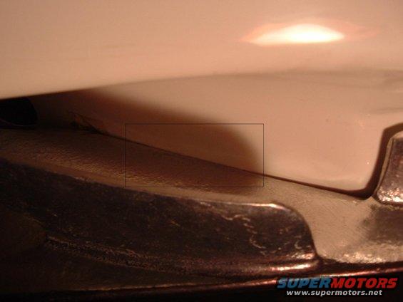 Close-up of a dark, textured car part against a smooth, light-colored surface