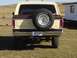 1979 Ford Bronco - The rear of a two-tone 1978 Ford Bronco is shown parked in a grassy, outdoor area.
