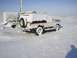 1979 Ford Bronco - A classic Ford Bronco sits covered in snow, with a trailer nearby in a winter landscape.