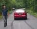 1995 Ford Mustang - Man walks away from a red 1995 Ford Mustang on a country road, with another vehicle visible ahead.