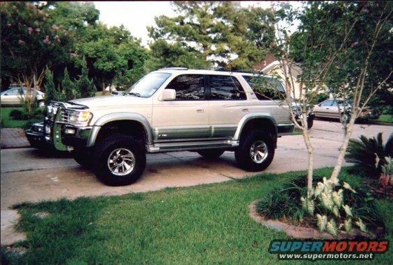 Silver SUV with off-road tires and brush guard, side view