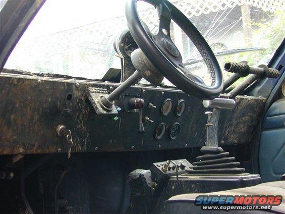 Interior view of a dirty vehicle dashboard with a steering wheel and gear shifter