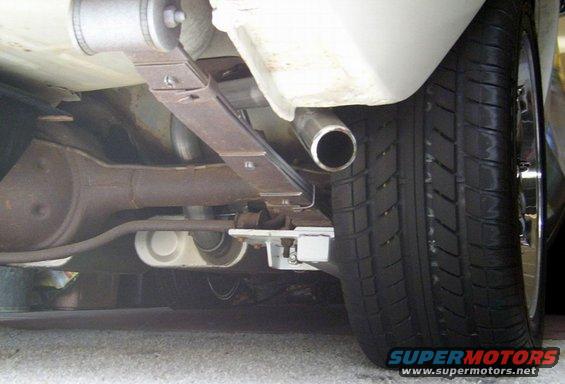 Close-up of a car's rear axle, leaf spring, and exhaust pipe