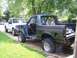 1990 Ford Bronco - A disassembled 1990 Ford Bronco sits with flat tires beside a white pickup truck in a driveway.