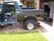 1990 Ford Bronco - This SUV, possibly a Ford Bronco, is in a state of disrepair with a flat tire and missing door.