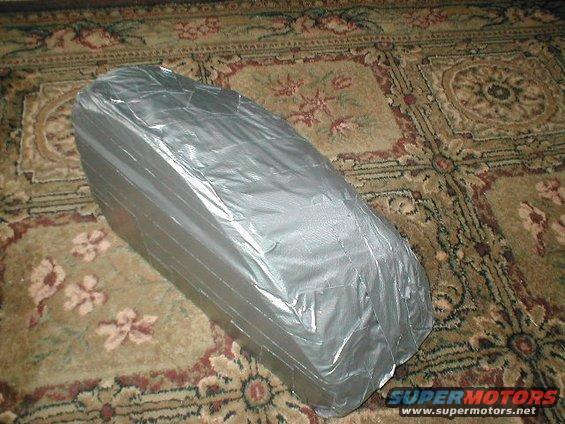 Object covered in silver duct tape on a patterned rug