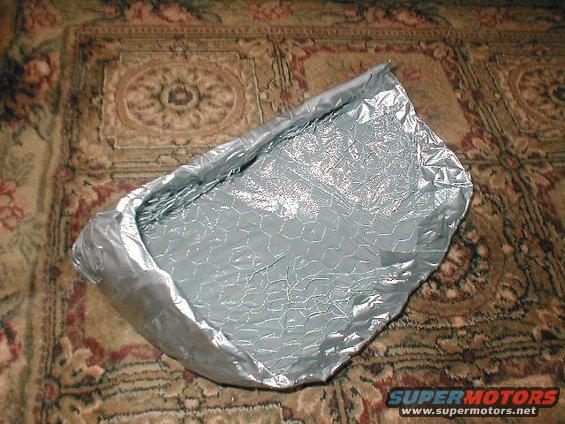 Silver insulation material with a hexagonal pattern, lying on a patterned carpet