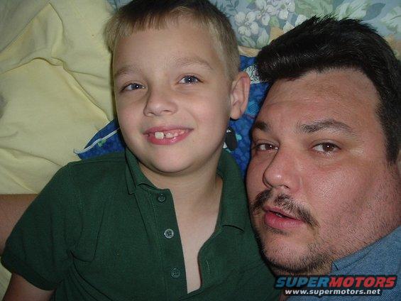 Man and young boy posing for a selfie. Boy has a gap in his front teeth
