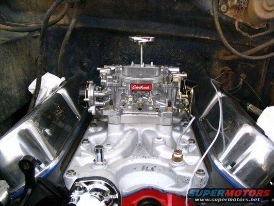 Engine bay with a chrome Edelbrock carburetor and chrome valve covers