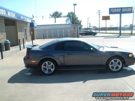 Dark gray 2003 Ford Mustang GT coupe, side view, chrome wheels