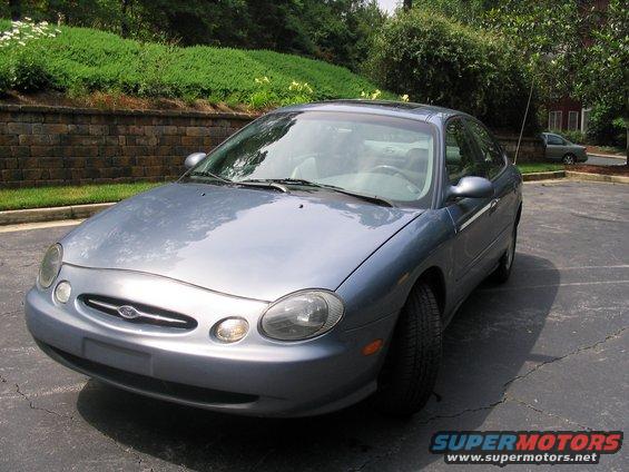 Blue sedan parked in a lot, front quarter view. The grille has a Ford logo