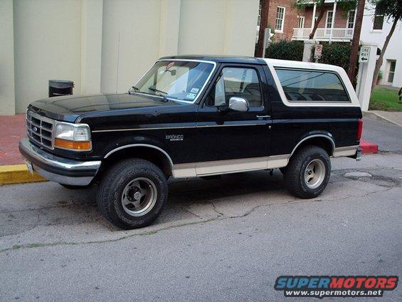 Black 1993 Ford Bronco with a white top parked on a street