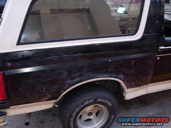 1993 Ford Bronco rear quarter panel with black paint and white trim