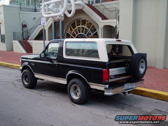 Black and white Ford Bronco parked on street, rear view