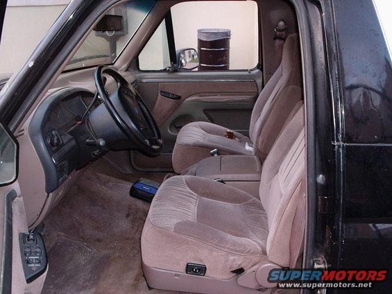 Interior of a 1992 Ford Bronco, showing tan cloth seats, dashboard, and steering wheel