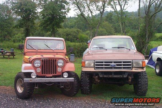 Brown Ford F-Series truck parked next to a red Jeep, front view