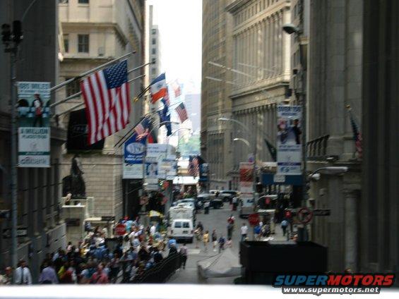 Street scene in a city with American flags, banners, and many pedestrians