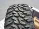 1990 Ford Bronco - A off-road tire is shown in detail, resting in the cargo area of a vehicle.