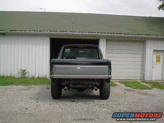Rear view of a black and silver pickup truck, possibly a Ford Bronco from the 1980s