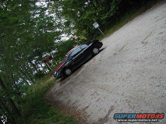 Black 1997 Ford Taurus sedan parked on a gravel road