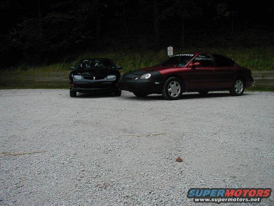 Maroon sedan with car bra parked next to black sedan