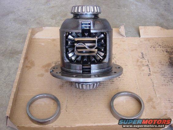 Differential assembly with gears visible, next to two rings. Supermotors logo at bottom right