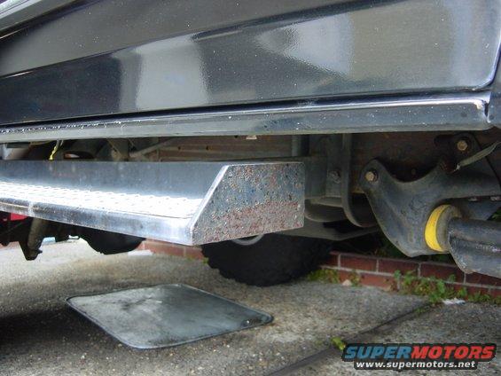 close-up of a vehicle's side, showing the running board and undercarriage components