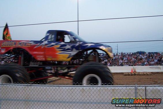 Monster truck with stars and stripes paint scheme in motion, side view
