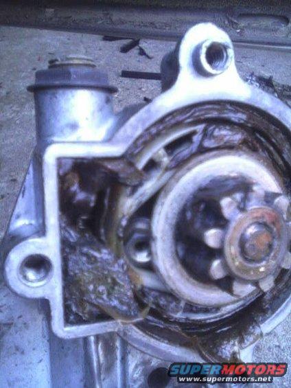 Close-up of a starter motor with visible gears and grease