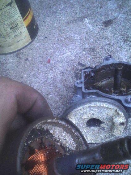 close-up of disassembled automotive part with copper wiring and gritty residue
