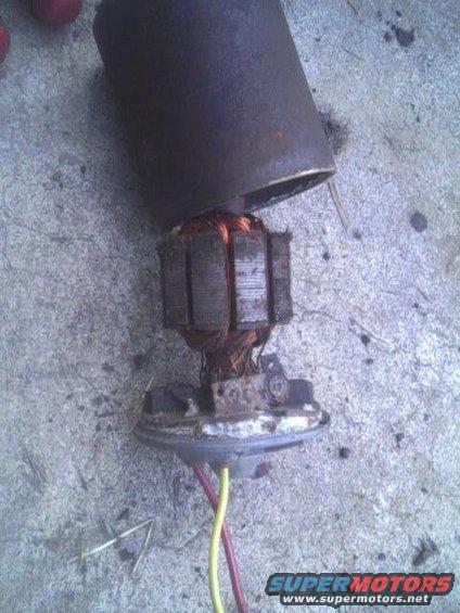 Rusty automotive motor armature with copper windings and wires on concrete